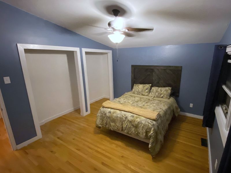 The same bedroom with both closets finished and trimmed in white, and the walls painted blue.